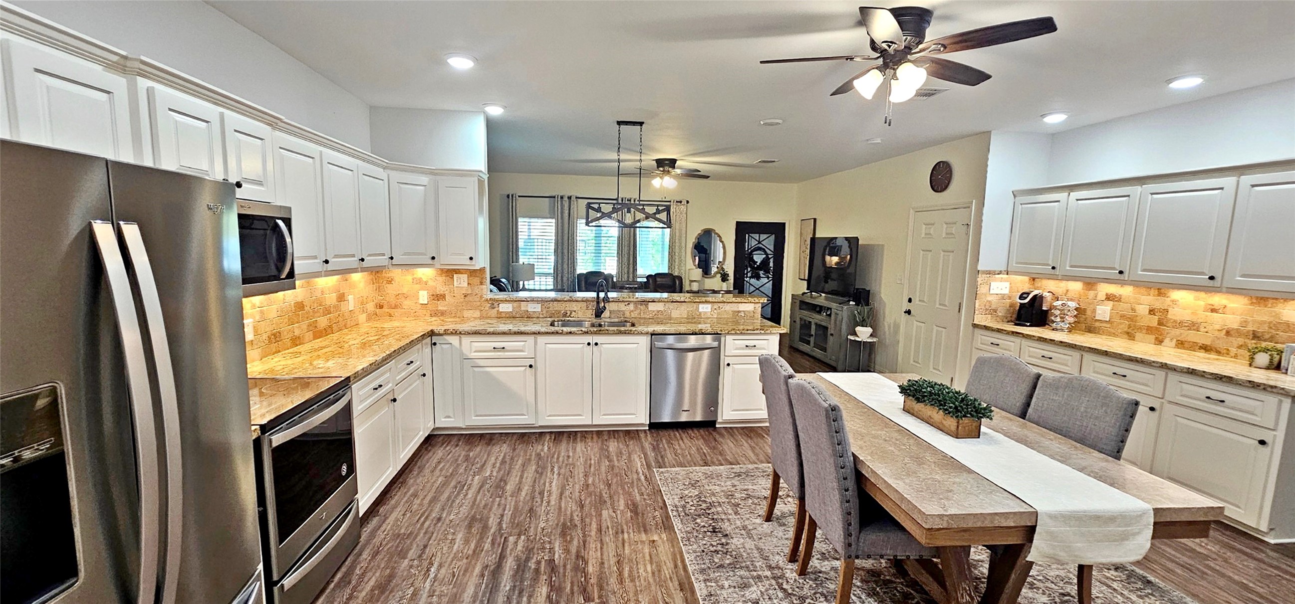 201 Smith Street Columbus, TX 78934 - Photo 6 of 20 a kitchen with stainless steel appliances granite countertop a refrigerator a sink dishwasher a stove and white countertops with wooden floor