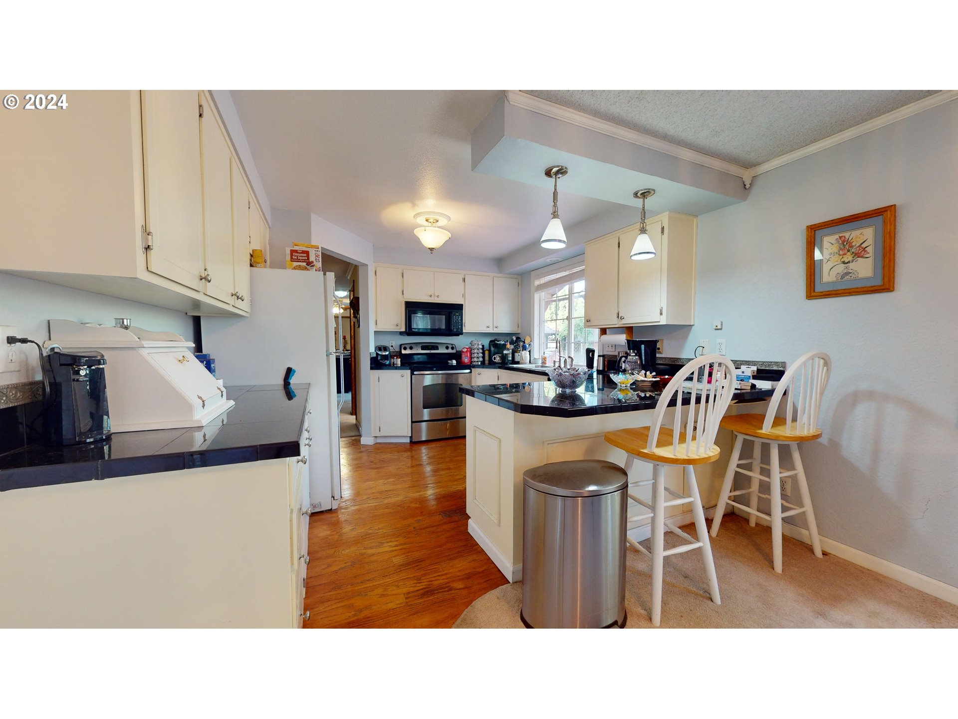 631 Rayner Avenue Springfield, OR 97477 - Photo 11 of 40 a kitchen with stainless steel appliances kitchen island granite countertop a table chairs sink and cabinets