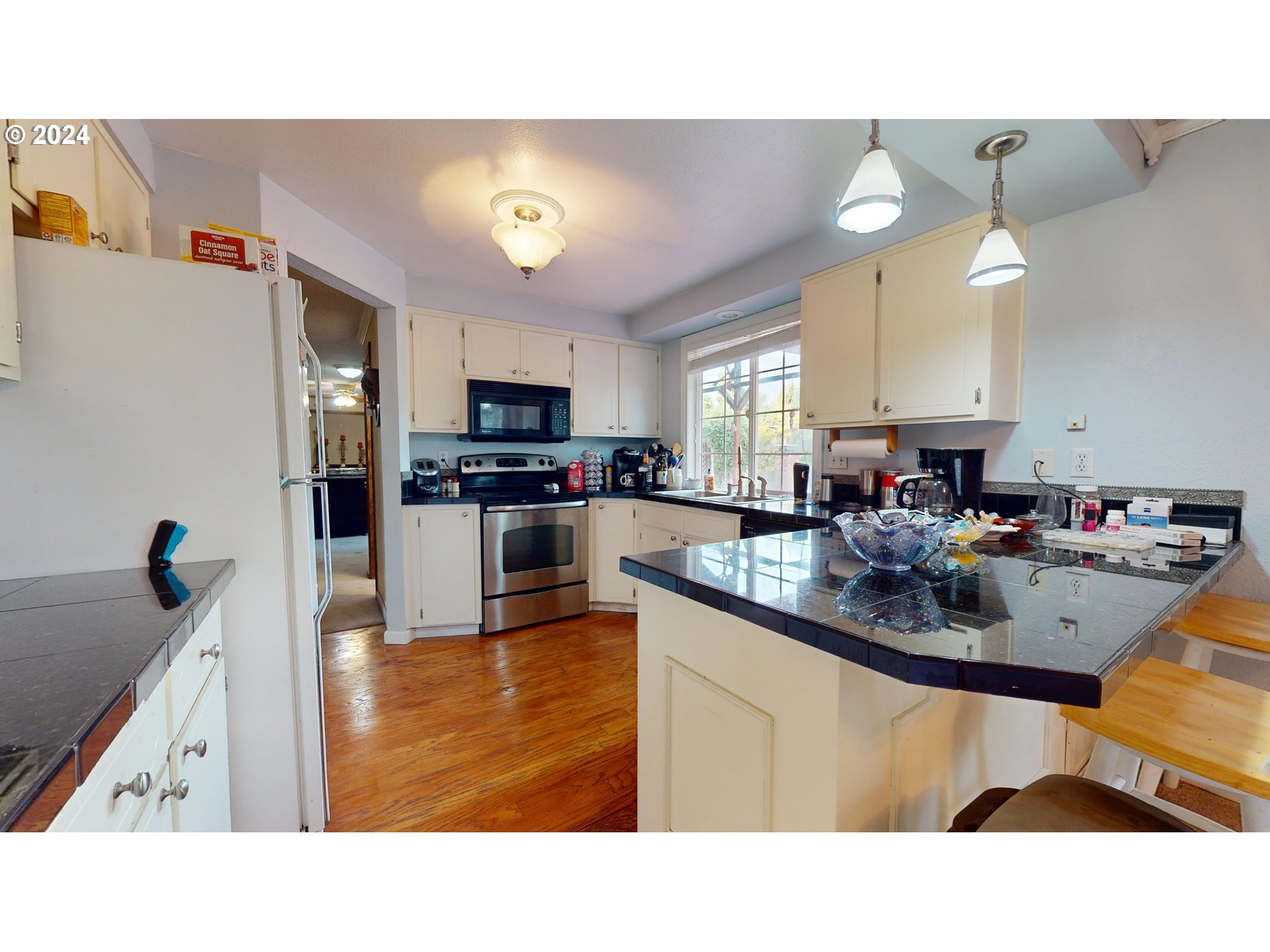 631 Rayner Avenue Springfield, OR 97477 - Photo 8 of 40 a kitchen with kitchen island stainless steel appliances a sink a counter top space cabinets and a couch