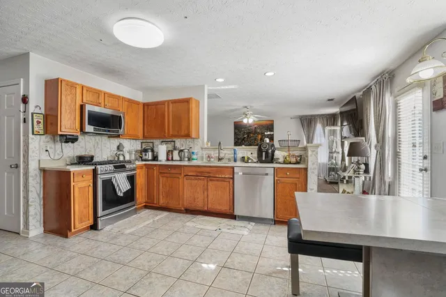 a kitchen with a sink a counter top space stainless steel appliances and cabinets