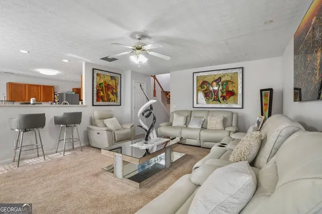 a living room with furniture and a ceiling fan