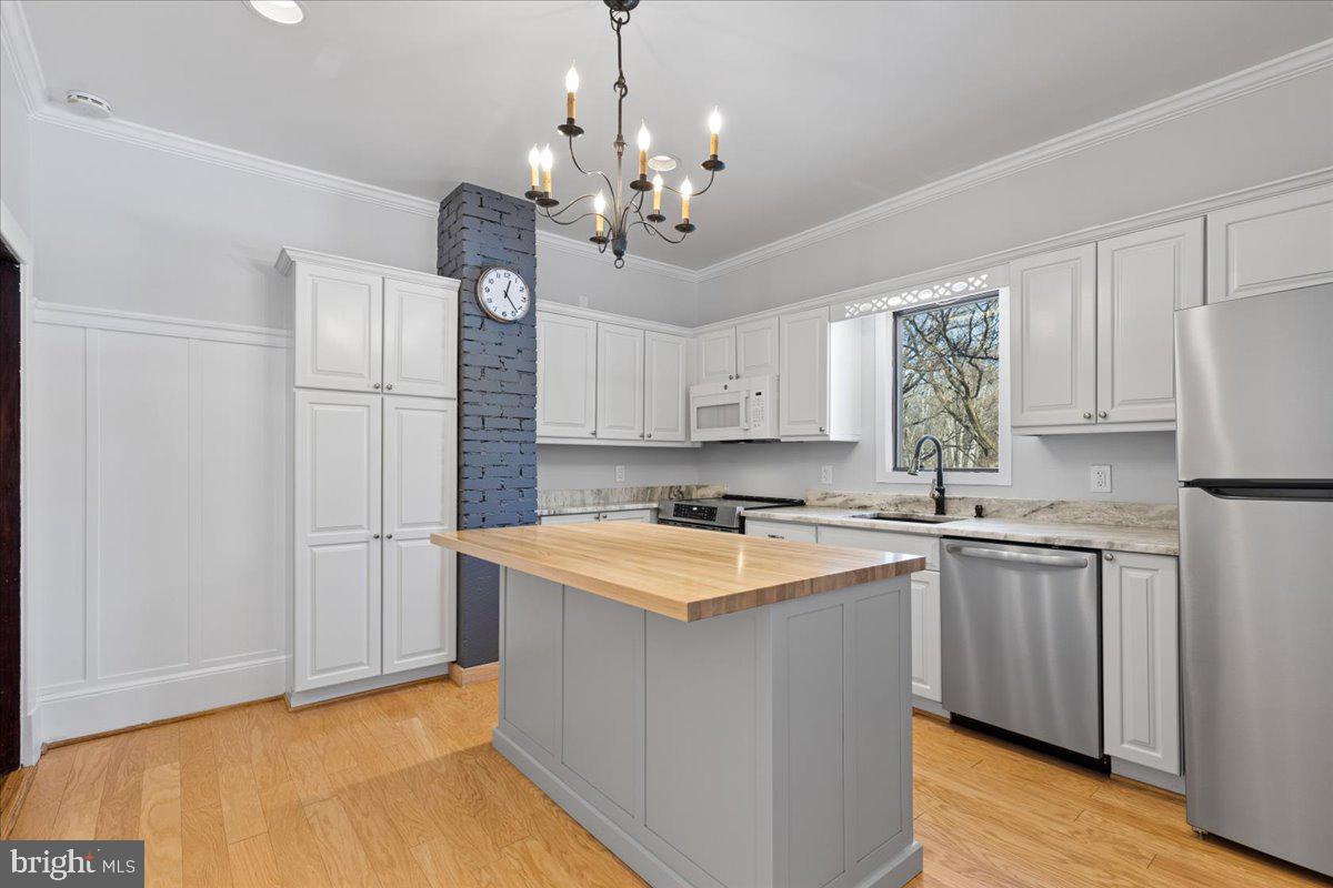 23320 Watson Road Leesburg, VA 20175 - Photo 6 of 51 a kitchen with a sink a chandelier stainless steel appliances cabinets and a window