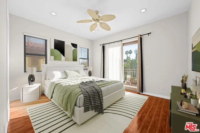 a bedroom with a large bed a chandelier and windows
