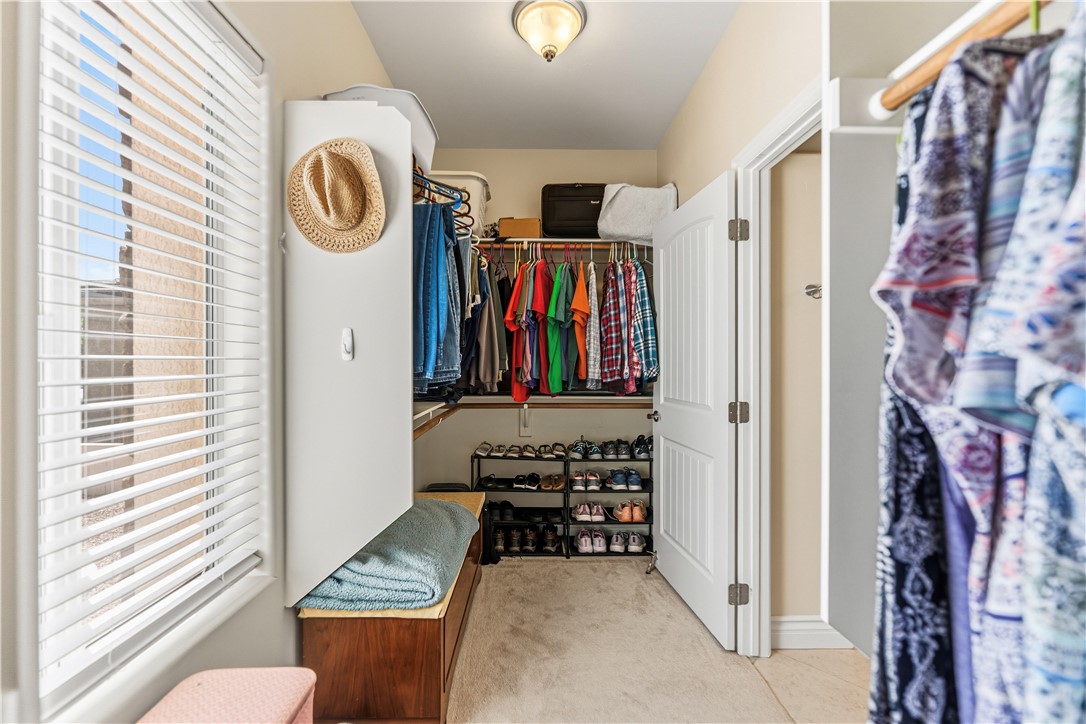 3315 Rainbow Mine Road Kingman, AZ 86401 - Photo 29 of 54 This walk-in closet features carpet flooring, a window with blinds, and built-in shelving for storage