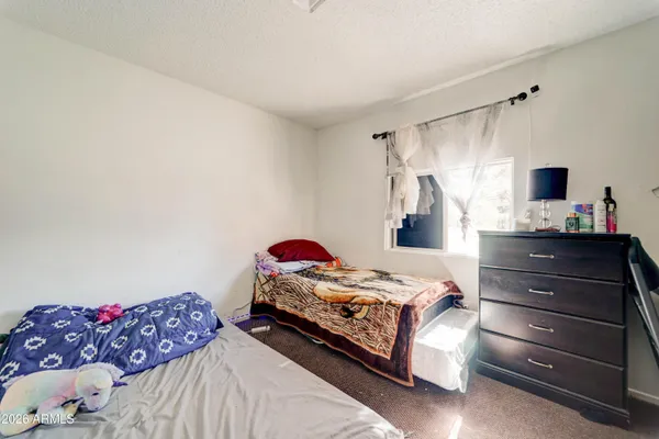 a bed sitting in a bedroom next to a window