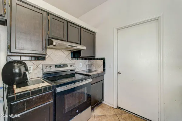 a kitchen with stainless steel appliances granite countertop a refrigerator a stove and a sink