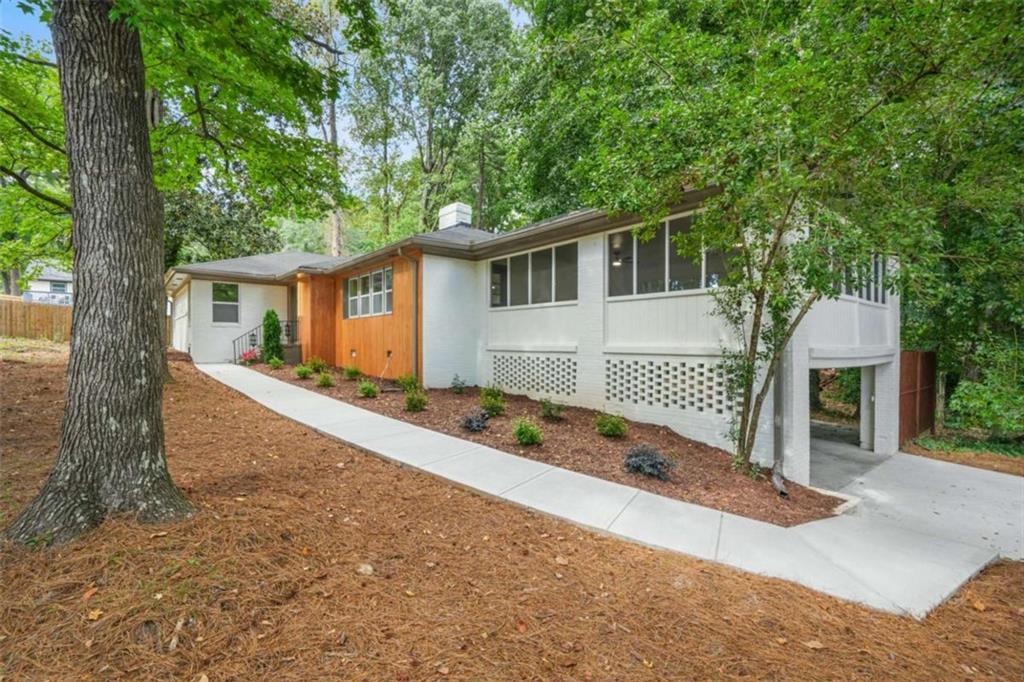 5975 Brookgreen Road Northeast Atlanta, GA 30328 - Photo 1 of 1 front view of house with a yard and large trees