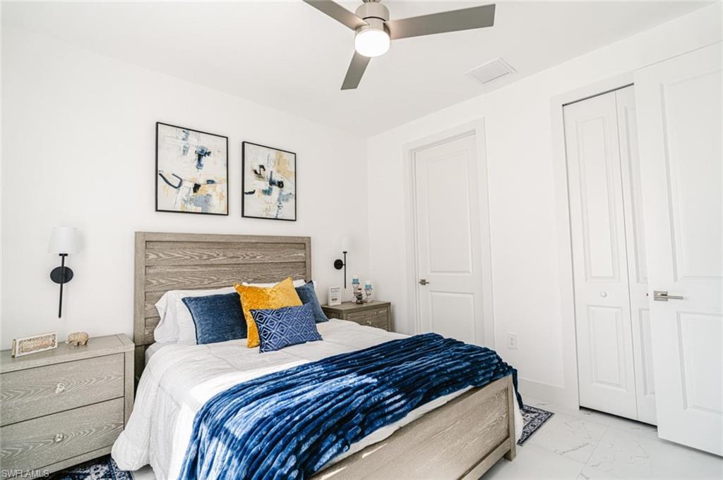 907 Homestead Road South Lehigh Acres, FL 33974 - Photo 17 of 43 Bedroom featuring a wood-finish bed frame and headboard, white walls, and a ceiling fan with integrated lighting