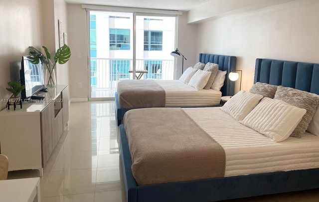 a bedroom with two beds and a flat screen tv