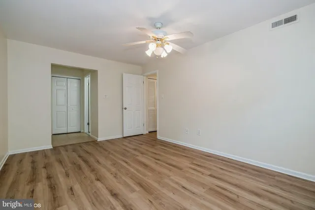 a view of an empty room with wooden floor
