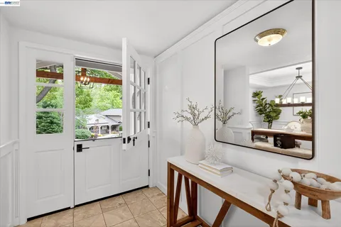 a kitchen with stainless steel appliances a dining table chairs stove refrigerator and cabinets