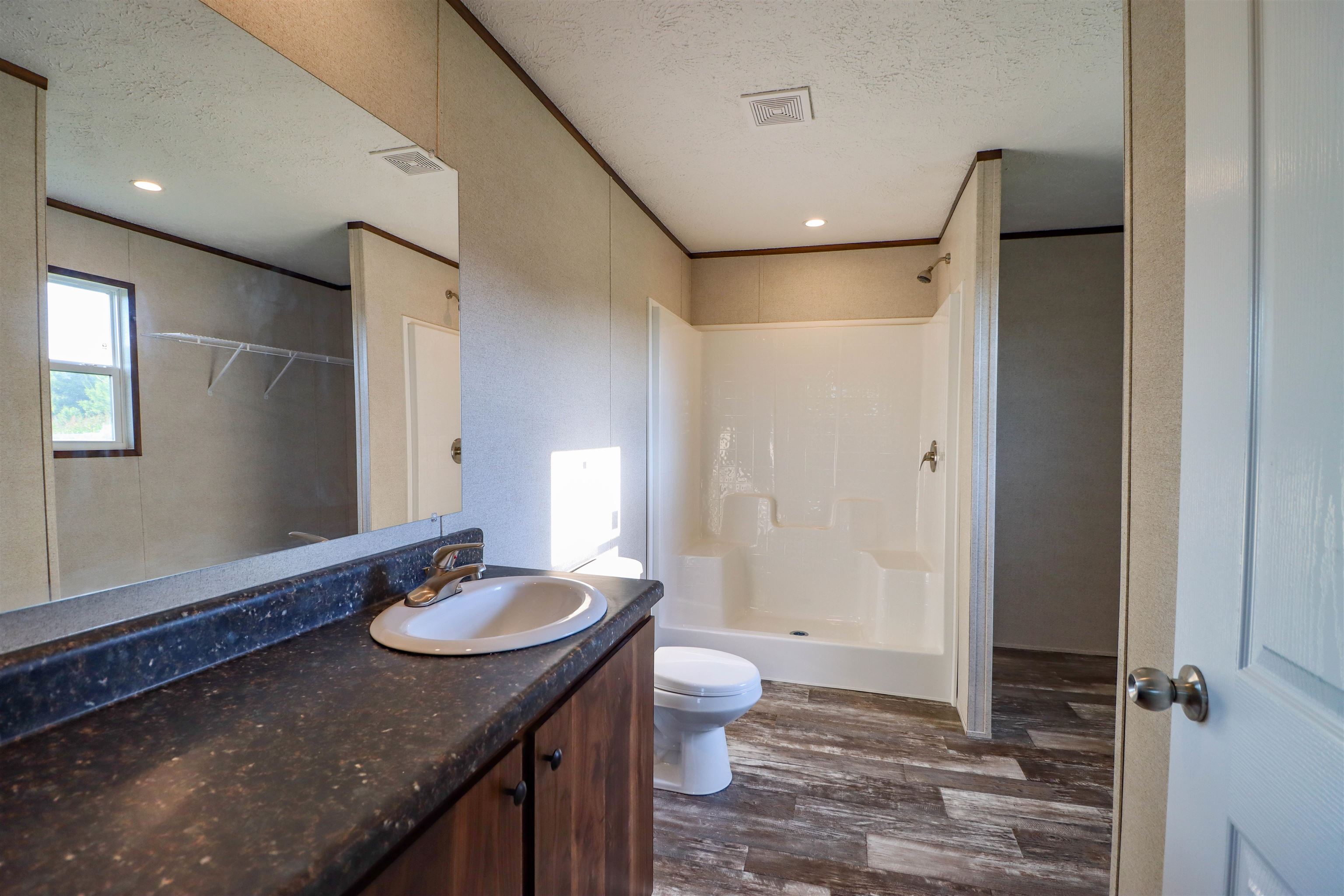 6483 Hwy 19 Highway West Ripley, TN 38063 - Photo 12 of 33 Bathroom featuring oversized vanity, walk in shower, a textured ceiling, hardwood / wood-style flooring, and toilet