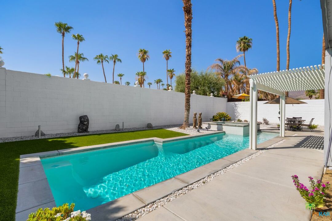 73501 Silver Moon Trail Palm Desert, CA 92260 - Photo 33 of 38 a view of a swimming pool with a table and chairs