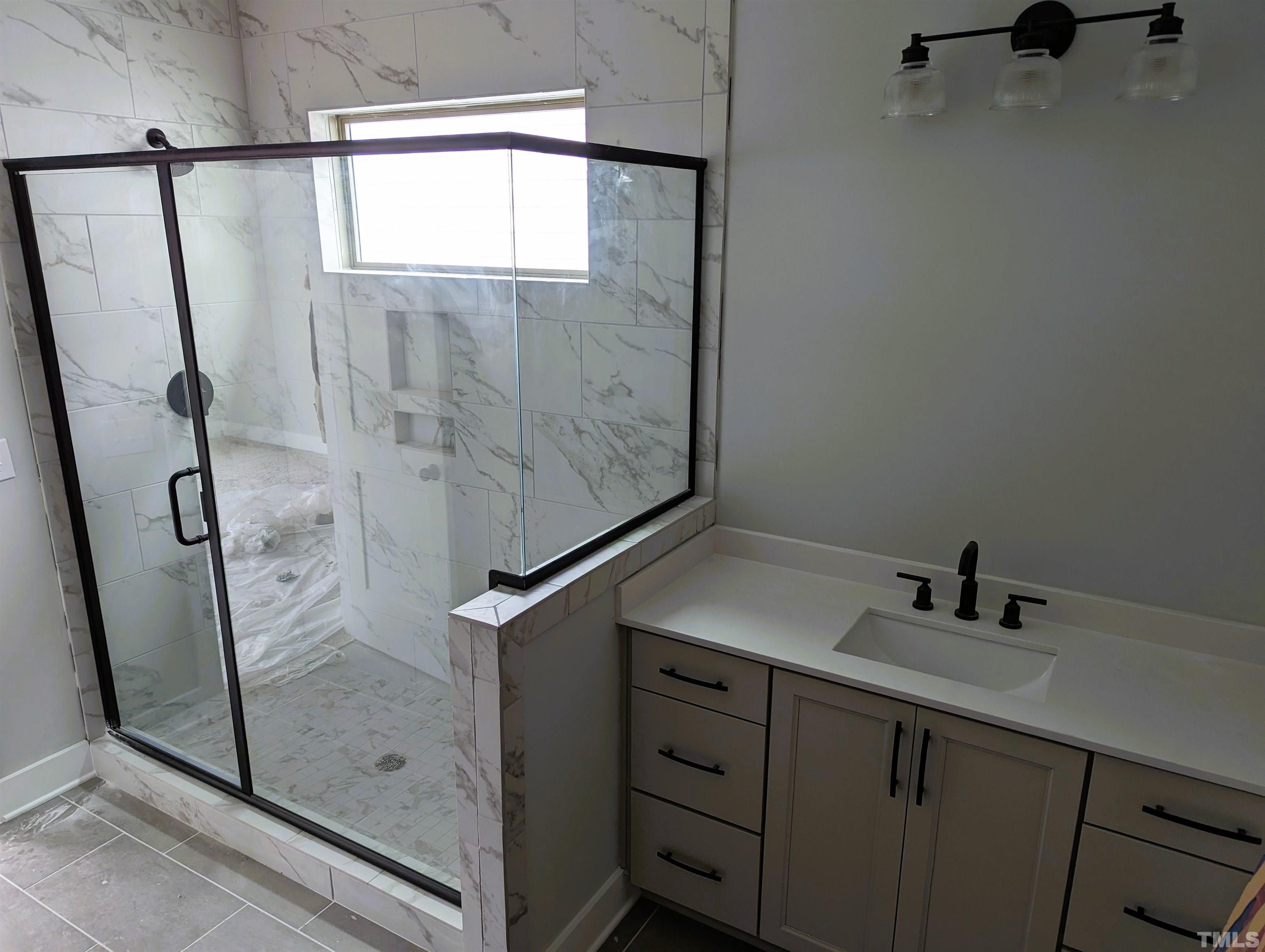200 East Moore Street Apex, NC 27502 - Photo 9 of 19 a bathroom with a shower sink and mirror