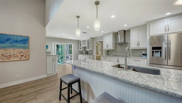 a large kitchen with stainless steel appliances granite countertop a lot of counter space and wooden floor