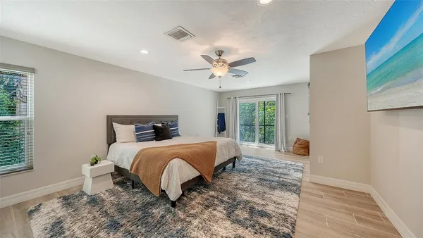 a bedroom with a large bed and a chandelier