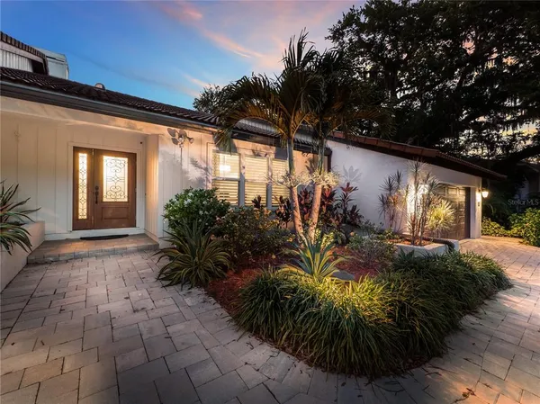 a front view of a house with a yard and potted plants