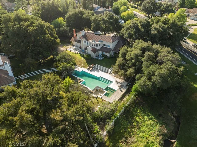 an aerial view of residential houses with outdoor space and trees