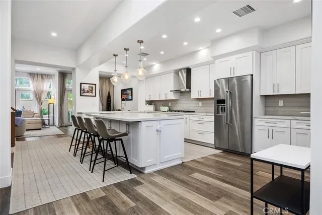 a kitchen with stainless steel appliances a dining table chairs microwave and sink