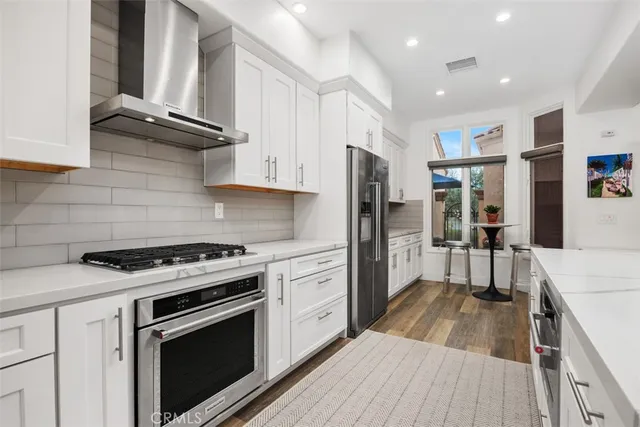 a kitchen with stainless steel appliances granite countertop a stove a refrigerator and a cabinets