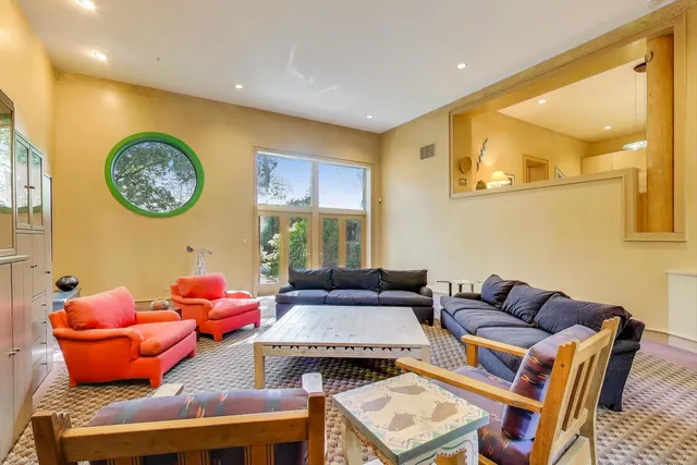 a dining room with stainless steel appliances kitchen island granite countertop a table chairs and a refrigerator