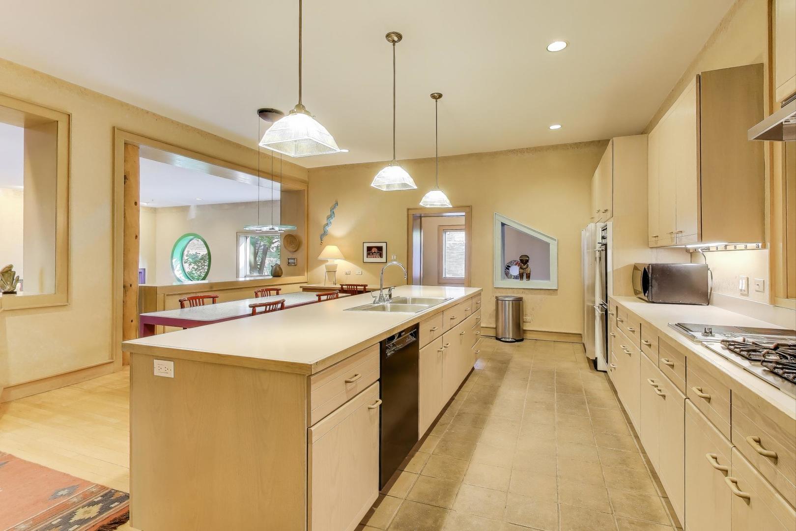 907-909 West Webster Avenue Chicago, IL 60614 - Photo 15 of 71 a large kitchen with kitchen island a stove a sink a center island and windows