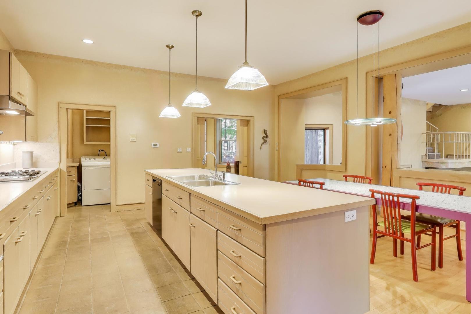 907-909 West Webster Avenue Chicago, IL 60614 - Photo 16 of 71 a large kitchen with kitchen island a island a sink a stove and a chandelier