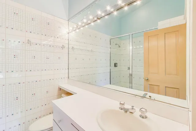 a bathroom with a sink a toilet and shower