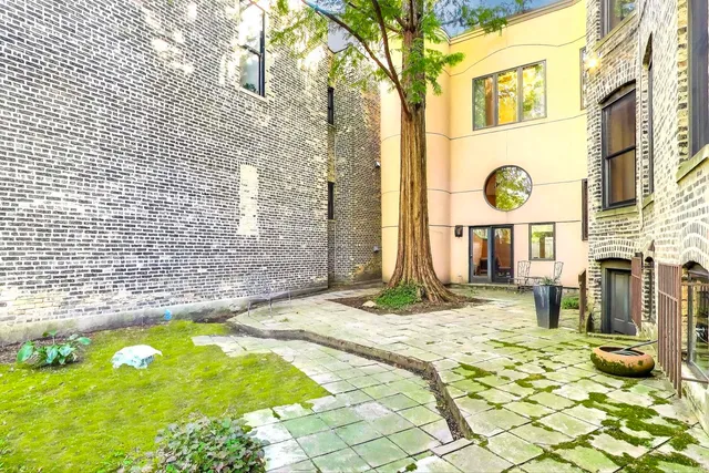 a kitchen with stainless steel appliances kitchen island granite countertop a table chairs and a refrigerator