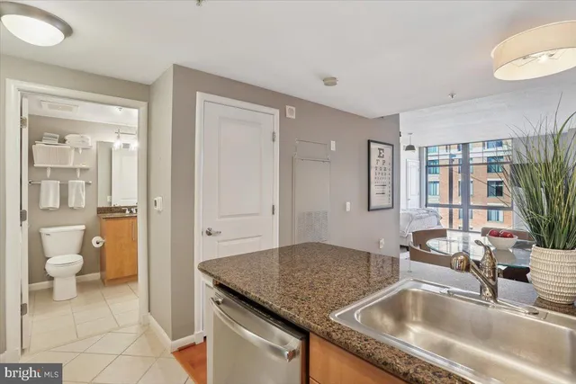 a kitchen with a granite countertop sink and natural light