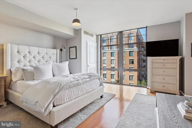 a bedroom with a large bed and a flat tv screen