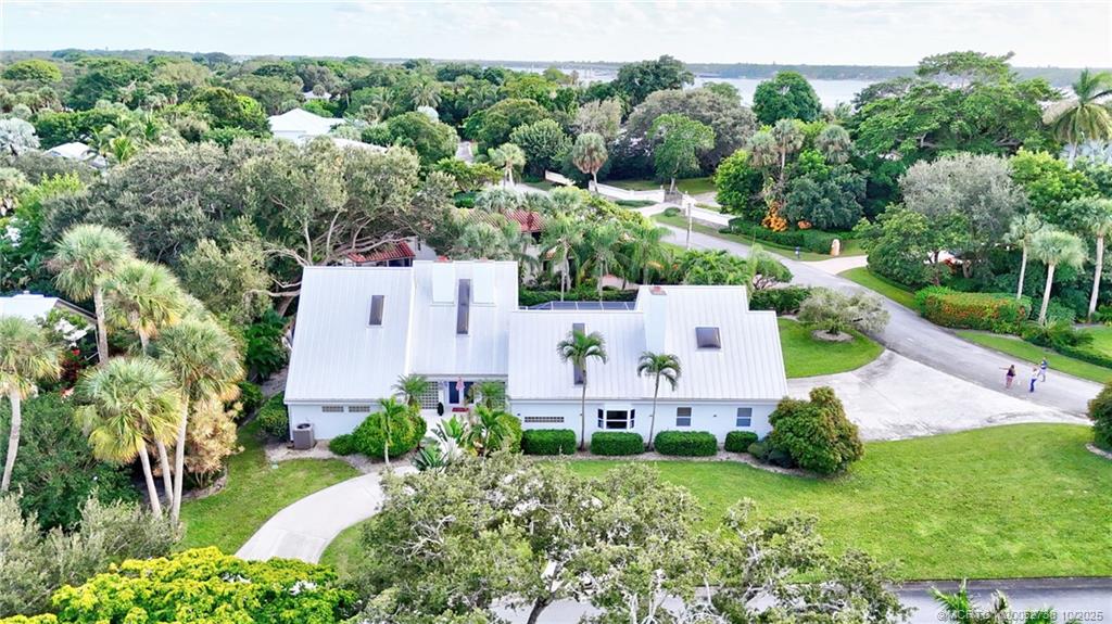 an aerial view of residential house with outdoor space and trees all around