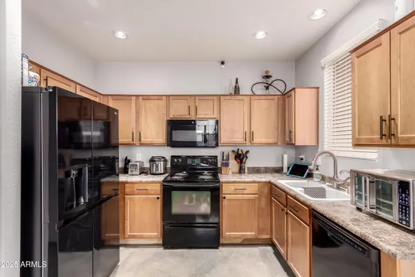 a kitchen with stainless steel appliances a sink cabinets and a stove top oven