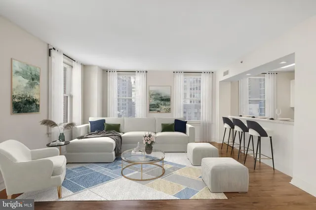a living room with furniture wooden floor and a large window