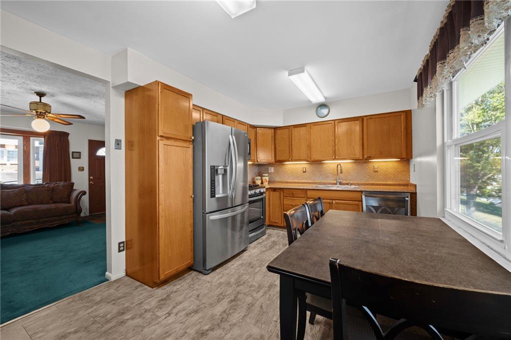 1213 Corrin Avenue Monongahela, PA 15063 - Photo 9 of 41 a kitchen with a refrigerator a stove and a dining table with wooden floor