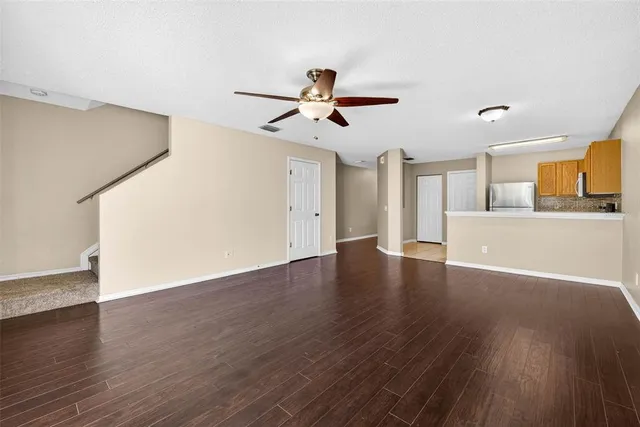 a view of a kitchen with wooden floor and a ceiling fan
