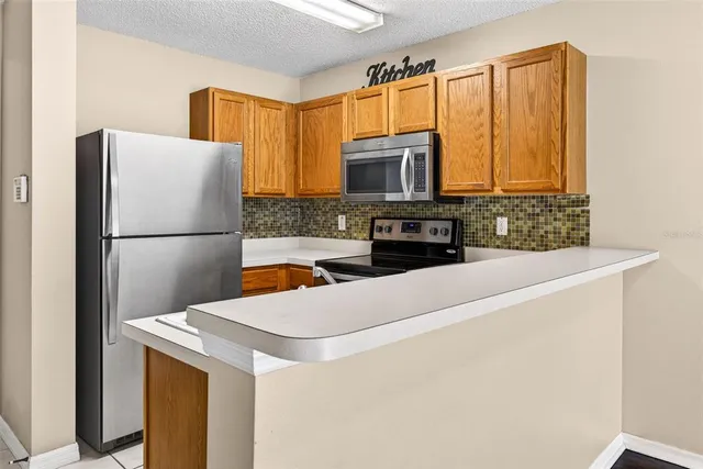 a kitchen with stainless steel appliances a refrigerator stove microwave and sink