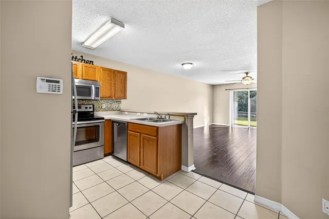 a kitchen with stainless steel appliances granite countertop a stove a sink and a refrigerator
