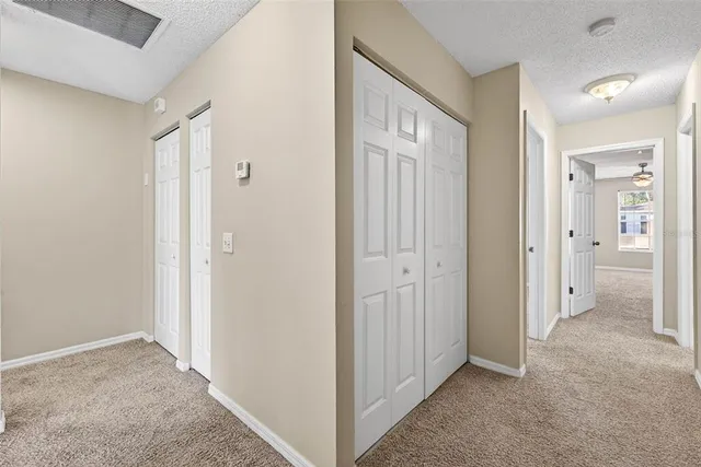 a view of a hallway with closet and bathroom