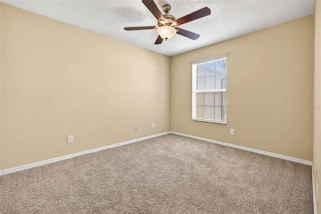 an empty room with a window and a fan