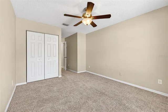 an empty room with a ceiling fan and a window