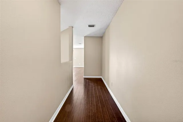 a view of a hallway with wooden floor