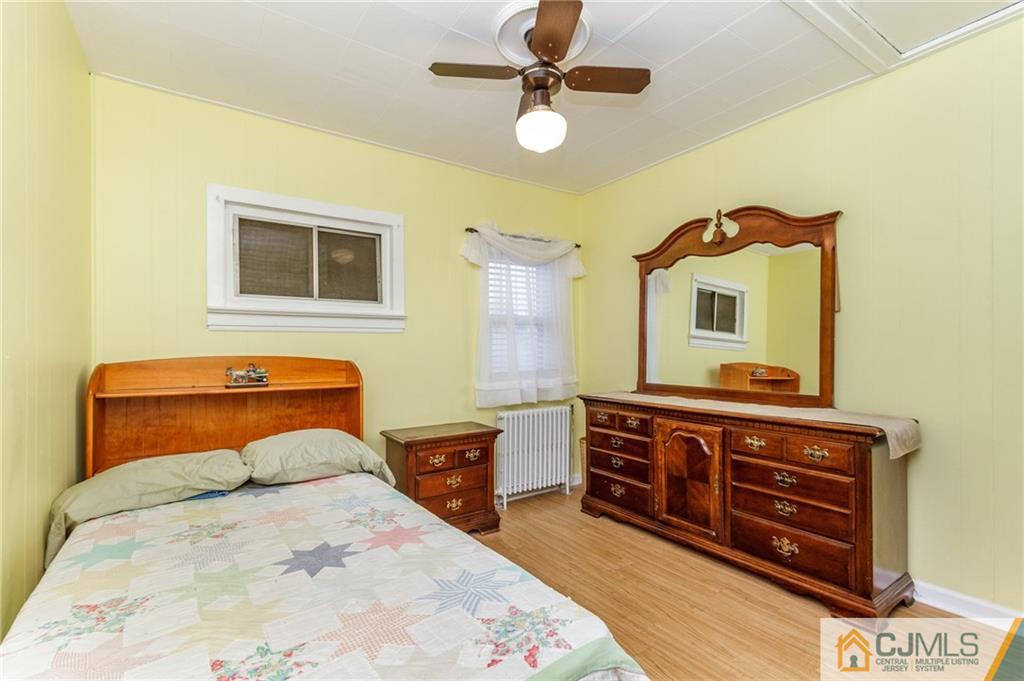 302 Norwood Avenue Old Bridge, NJ 08879 - Photo 12 of 19 a bedroom with a bed a dresser and potted plants on the dresser