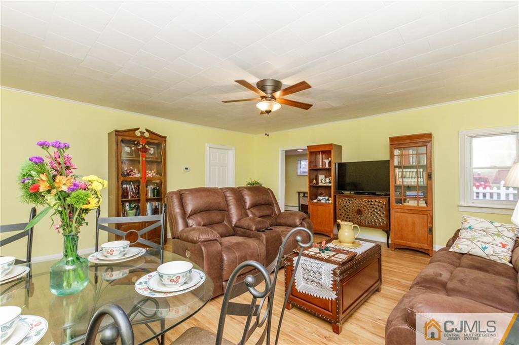 302 Norwood Avenue Old Bridge, NJ 08879 - Photo 6 of 19 a living room with furniture a chandelier and a dining table with wooden floor