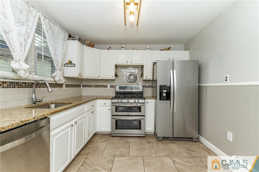 302 Norwood Avenue Old Bridge, NJ 08879 - Photo 8 of 19 a kitchen with stainless steel appliances granite countertop a refrigerator and a stove