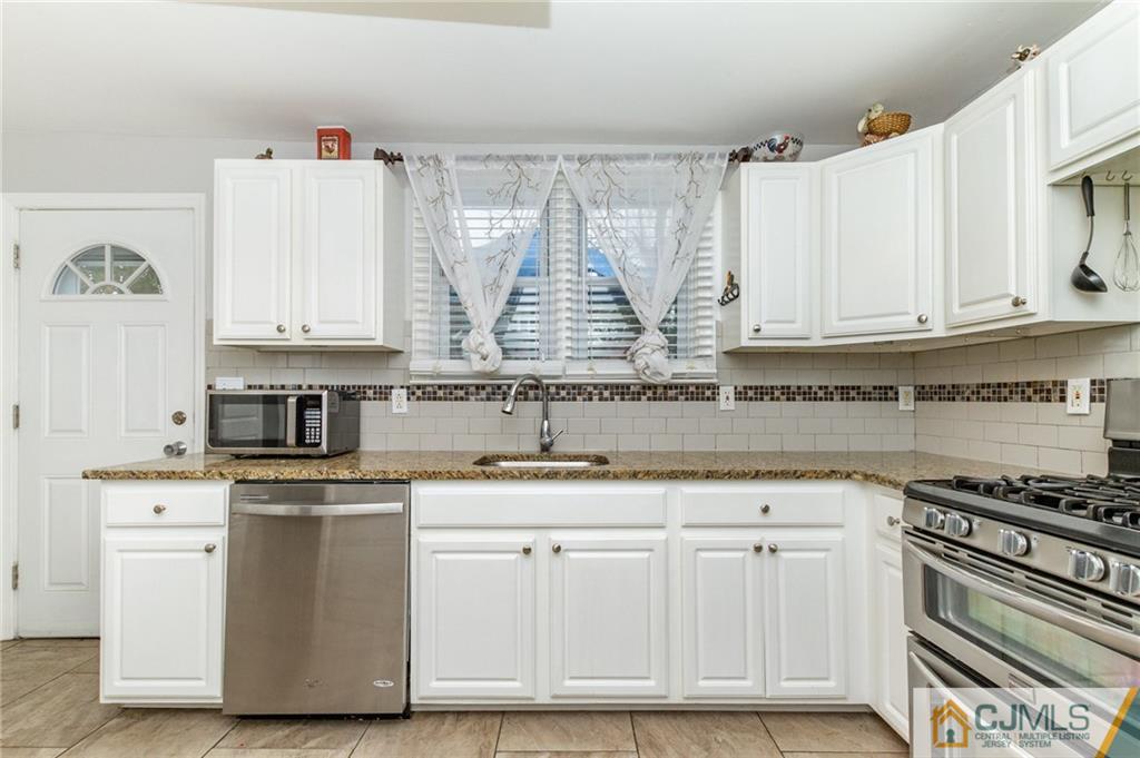 302 Norwood Avenue Old Bridge, NJ 08879 - Photo 9 of 19 a kitchen with stainless steel appliances granite countertop a sink and a stove
