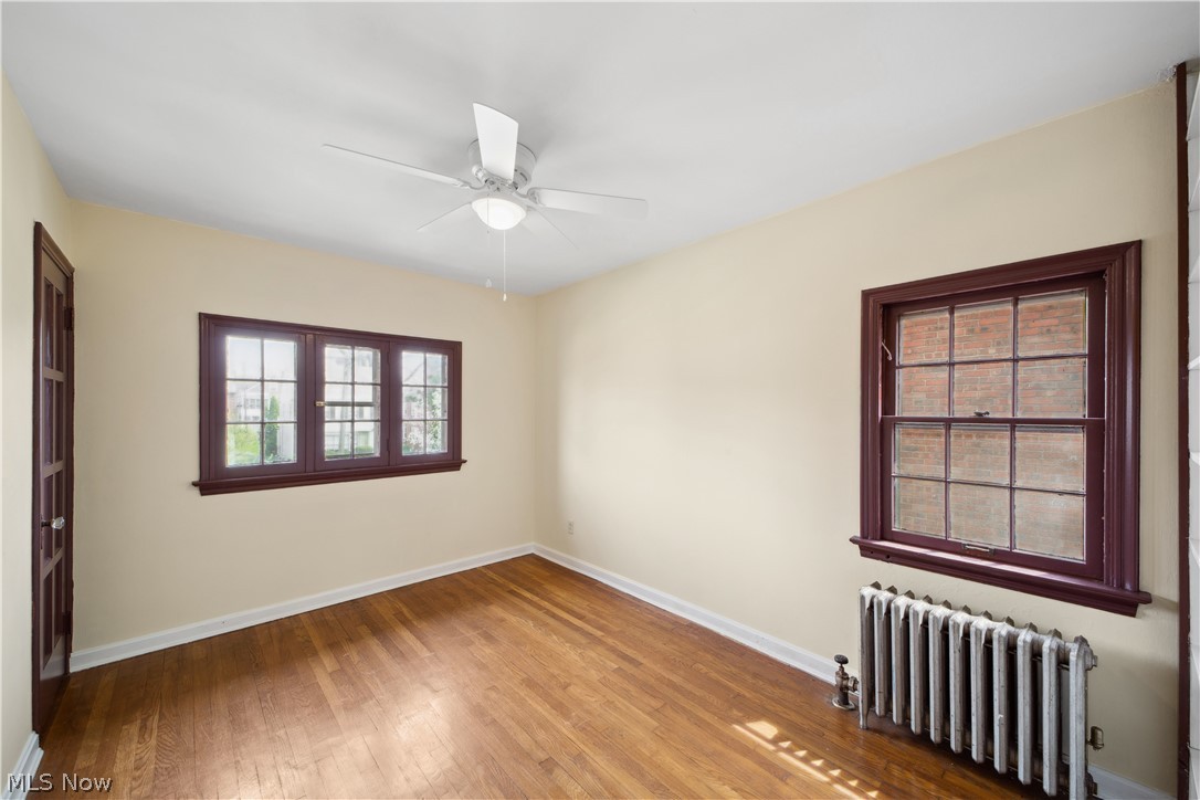 3666 Winchell Road Beachwood, OH 44122 - Photo 32 of 46 Unfurnished room featuring radiator, ceiling fan, and light hardwood / wood-style flooring