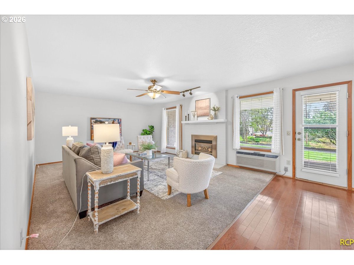 16444 Southwest 130th Terrace, Unit 121 Portland, OR 97224 - Photo 11 of 40 a living room with furniture a fireplace and a table