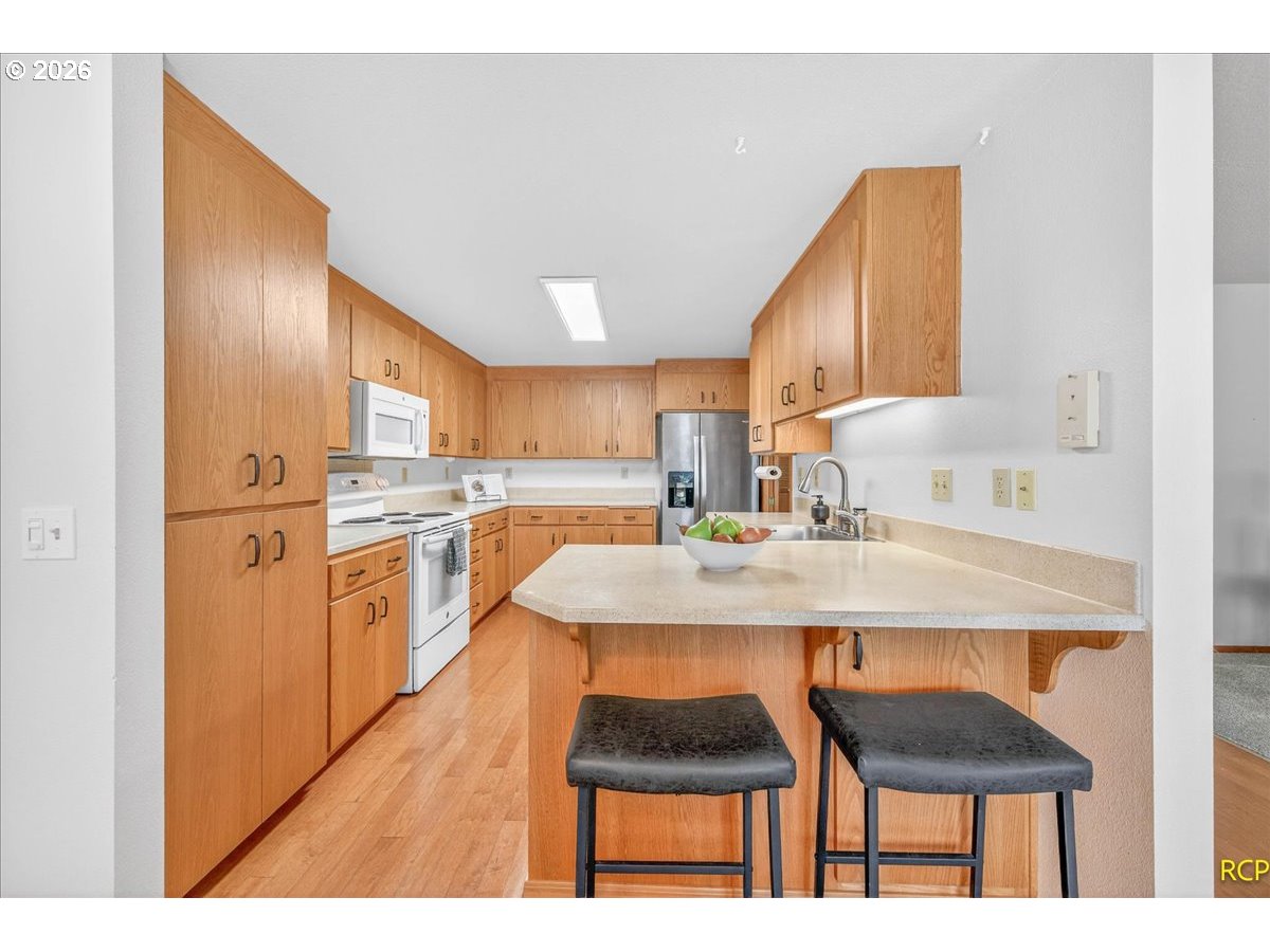 16444 Southwest 130th Terrace, Unit 121 Portland, OR 97224 - Photo 18 of 40 a kitchen with a sink cabinets and wooden floor