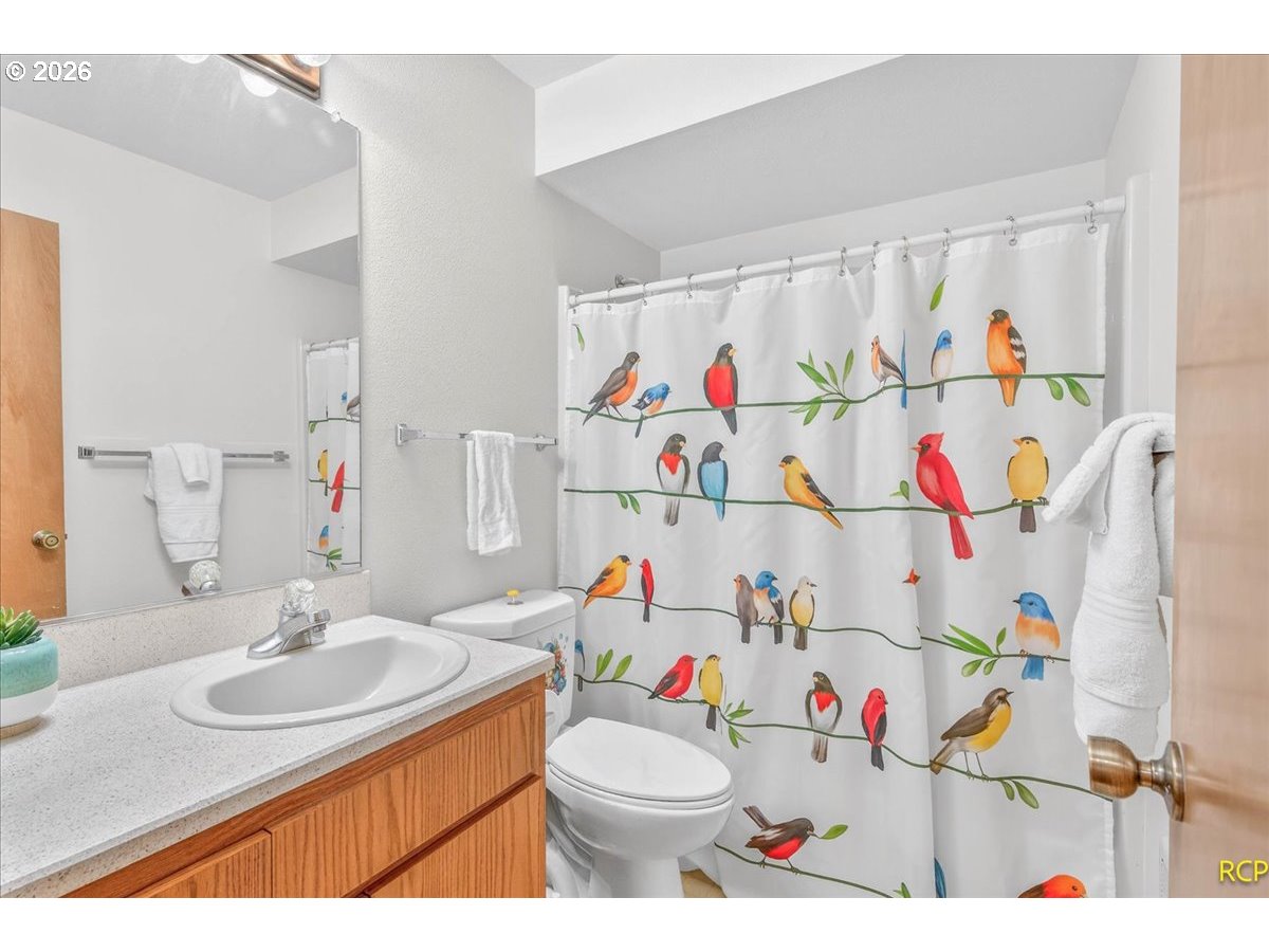 16444 Southwest 130th Terrace, Unit 121 Portland, OR 97224 - Photo 23 of 40 a bathroom with a sink toilet vanity and curtain